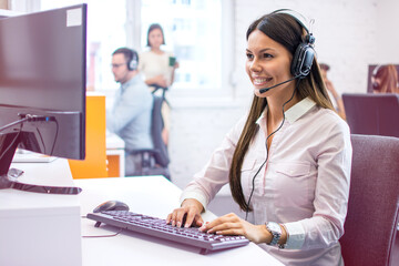 Sticker - Smiling woman operator working on computer in customer support agency. Help-desk, tech support, online services and sales concept.