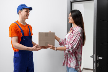 Canvas Print - Woman receiving parcel from courier at home