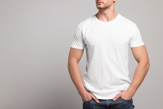 Wall Mural - Man wearing white t-shirt on light grey background, closeup. Mockup for design