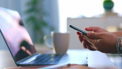 Wall Mural - Hands, phone and laptop for remote work and drinking coffee while working on home office table. Freelance woman with smartphone in hand for cloud computing, information technology and internet scroll