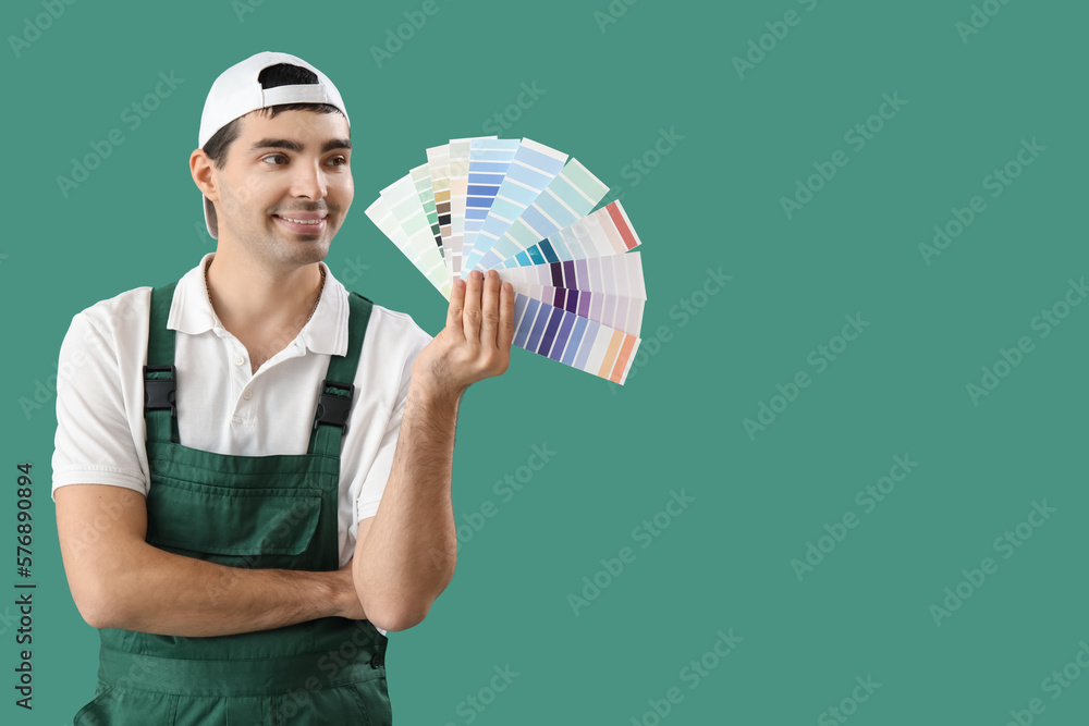 Male painter with color palettes on green background