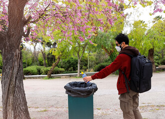  Man hand putting  bottle of a plastic reuse for recycling concept environmental protection world recycle in park