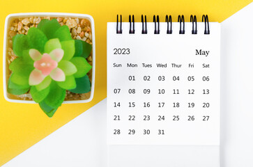 The May 2023 Monthly desk calendar for 2023 year with small tree on yellow background.