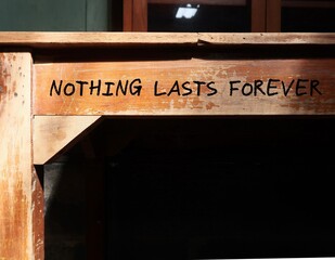 vintage school desk with black copy space shadow and handwritten text nothing lasts forever, means n