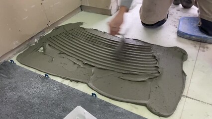 Wall Mural - 4k video footage of laying a large wide-format tile for mortar.