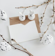 Card Mockup, Envelope ,Easter Eggs And Funny Bunny Decor ,spring Willow Branches  In Neutral Colors On White  Background Top View Flatlay. Copy Space.Easter Background.