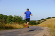 © sports photos - back male runner running on road on plain