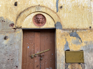 An old, abandoned house with a beautiful Portuguese era carving above a wooden door in the city of Panaji.