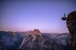 © Cavan Images - Man standing on an overhanging rock with the Half Dome in the background. Yosemite, CA,USA.