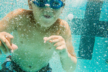 A Young Boy Swims Under Water.