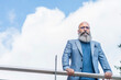 © Cavan Images - hipster man leaning on a fence looking at the camera