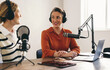 © Jacob Lund - Two happy women co-hosting a podcast in a home studio