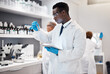 © Malik E/peopleimages.com - Science, research and black man test tube and tablet for medical analysis and innovation in laboratory. Pharmaceutical analytics, medicine study and scientist in South Africa checking vaccine results
