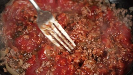 Wall Mural - Cooking Bolognese Sauce For Pasta In Pan. Stirring tomato sauce and minced meat