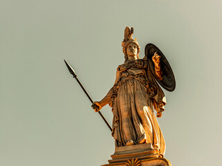 Statue of Athena, the ancient Greek goddess of wisdom and knowledge, who is represented as a powerful warrior with helmet, shield and spear. Travel to Athens, Greece.