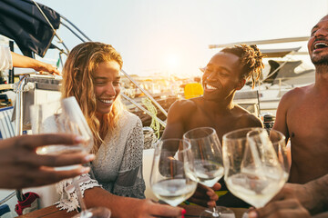 Wall Mural - Multiracial people having fun cheering with wine at boat party outdoor - Focus on right man face