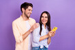 © deagreez - Photo of laughing carefree overjoyed people together friendship hold smartphone enjoy read internet blog isolated on violet color background
