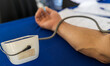 © kaentian - Close-up view of doctor hand measuring blood pressure by strapping device to patient's arm.