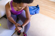 © Wavebreak Media - High angle view of mid adult african american woman using smart watch while doing workout at home