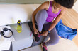 © Wavebreak Media - High angle view of mid adult african american woman tying shoelace while doing workout at home