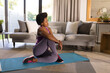 © Wavebreak Media - Mid adult african american woman practicing yoga at home