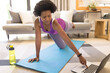 © Wavebreak Media - Mid adult african american woman practicing online yoga through laptop at home