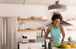 © Wavebreak Media - Happy mid adult african american woman chopping vegetables in kitchen at home