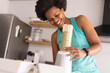 © Wavebreak Media - Mid adult african american woman smiling while preparing healthy breakfast in kitchen at home