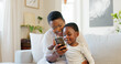 © Kirsten D/peopleimages.com - Surprise, phone and black family bonding on sofa in house or home living room with fun education, learning or esports game. Smile, happy or shocked mother and child on mobile technology with wow face