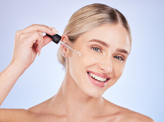 Wall Mural - Face, portrait and skincare of woman with serum in studio isolated on a blue background. Dermatology, beauty cosmetics and happy female model apply hyaluronic acid, retinol or essential oil product.