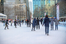 People Ice Skating On Outdoor Rink In Bryant Park, New York City, Daytime