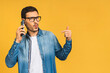 © denis_vermenko - Young caucasian man angry, frustrated and furious with his mobile phone, angry with customer service. Isolated over yellow background.