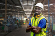 © ultramansk - Portrait of manuel African black man worker is standing with confidence with blue working suite dress and safety helmet in front machine and equipment for heavy industry factory. Steel plant.