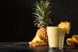 Pineapple lassie or smoothie on black background. Traditional healthy vegan asian beverage made of pineapple, yogurt and ice. Copy space.