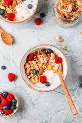 Healthy brakfast with yogurt and baked granola with berries in two small bowls.