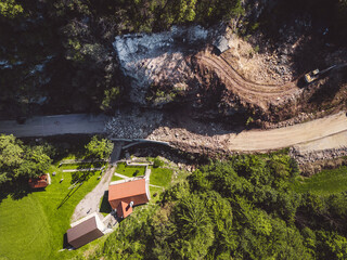 Wall Mural - Aerial view of a landslide on a hill across the residential building that remained unharmed 