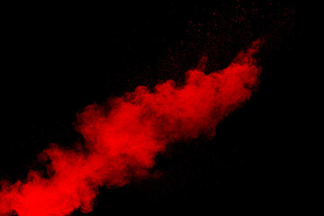 red powder explosion cloud on black background. freeze motion of red color dust particles splashing.