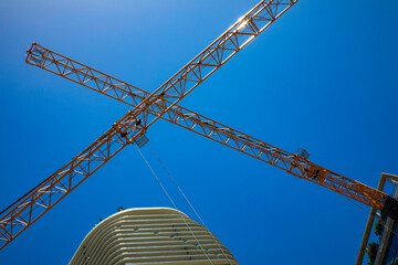 Construction cranes crossed against a blue sky, Miami, Florida