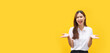 Banner with blank copyspace, Women are smiling and holding something in both hands while standing on isolated yellow background