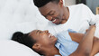 © Nina/peopleimages.com - Happy black couple in bedroom kiss and smile for love, romance and intimacy at house or home in morning. Young, happiness and kissing black woman and man or romantic black people dating bond together