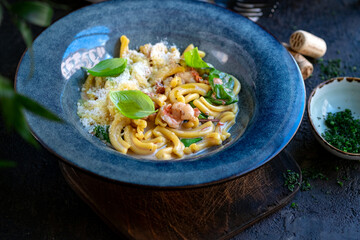 Wall Mural - Cooking casarecce pasta with shrimp, basil and cream sauce in a blue plate. Italian dish casarecce seafood