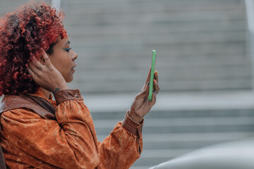 Wall Mural - profile girl on the street with mobile phone and afro hair