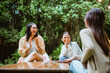 © Odua Images - woman in white t shirt clap her hands and laughing while chatting with her friends at camp site