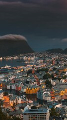 Wall Mural - Alesund, Norway. Day To Night Time-lapse. Dramatic Sky In Warm Colours Above Alesunds Islands In Sunset Time. 4K. Famous Town In Evening Night Time. Vertical, Vertical Shot, Vertical Video,