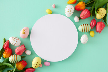 Wall Mural - Easter decoration concept. Flat lay photo of white circle red tulips flowers and colorful eggs on isolated turquoise background with blank space. Holiday card idea