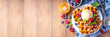 © ricka_kinamoto - Tasty Homemade Belgian waffles with raspberries, blueberries, vanilla ice cream and syrup or honey, sweet summer healthy breakfast, light wooden background copy space