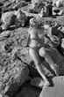 Dojrzała kobieta w bikini na kamienistej plaży