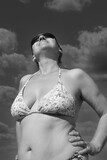 Fototapeta  - Wspomnienie lata. Portret kobiety w bikini na tle nieba