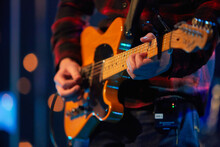 Guitarist Playing Electric Guitar On Stage. Close-up Of Male Hands Playing Electric Guitar.