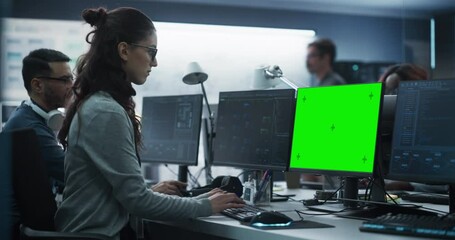 Female Software Developer Working on a Desktop Computer with Green Screen Mock Up Display. Busy Specialist Typing on Keyboard, Coding and Implementing a New Technical Feature, Working in an Agency